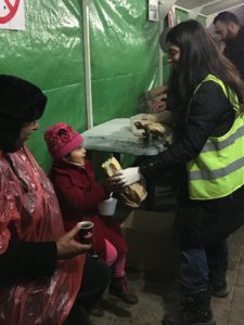 Volunteer feeding refugee child